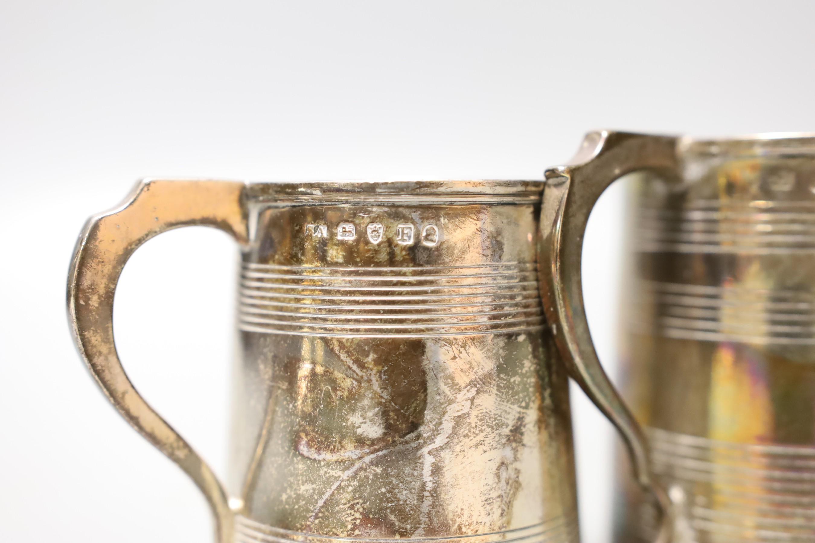 Three small Georgian silver mugs, two with two reeded bands, Stephen Adams I, London, 1801, 64mm and makers mark rubbed, London, 1808 (with later engraved inscription to the base) and one with three reeded bands, London,